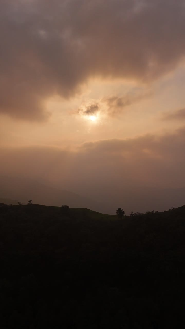 A vertical clip showing a dusty sky with the sun shining brightly behind the clouds, Green Mountains