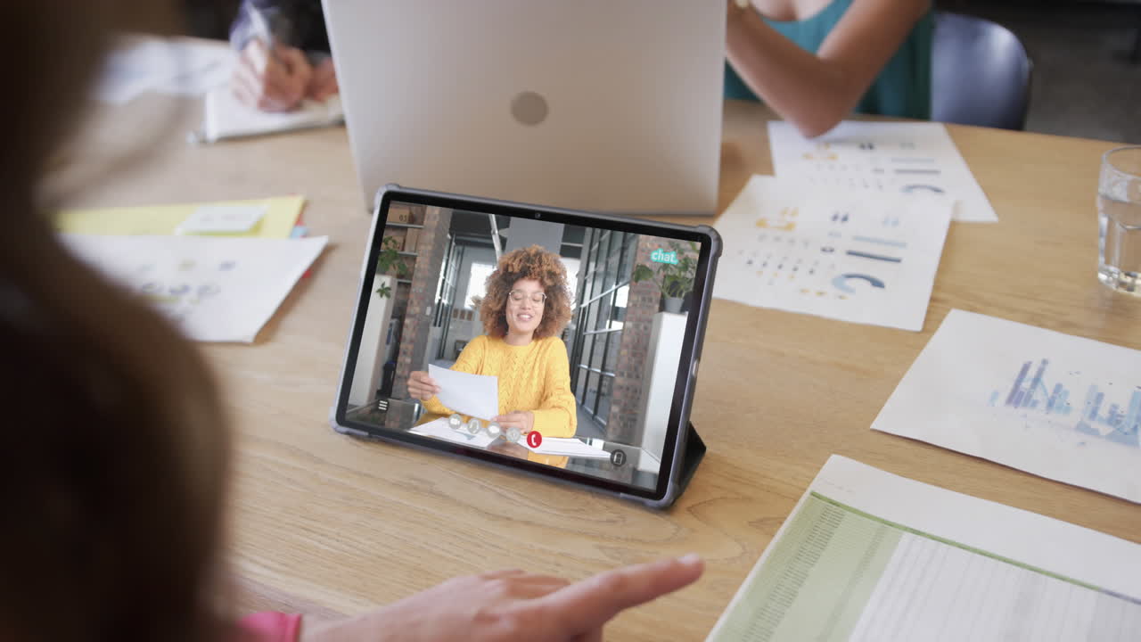 mujer de negocios caucásica en una videollamada con una colega afroamericana en la pantalla