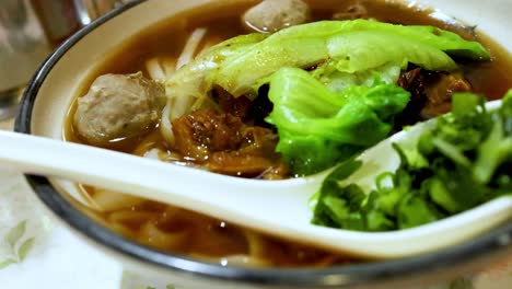 a bowl of beef noodle soup with vegetables