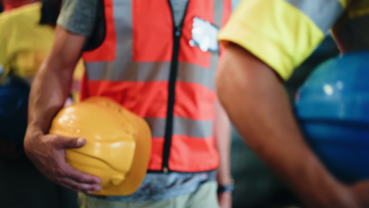 Trabajadores industriales llevando cascos de seguridad y vistiendo chalecos