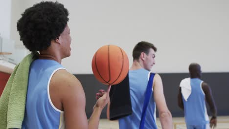 Diverse-male-basketball-team-training-in-indoor-court,-in-slow-motion