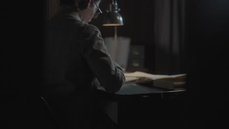 woman reading at desk in dim light
