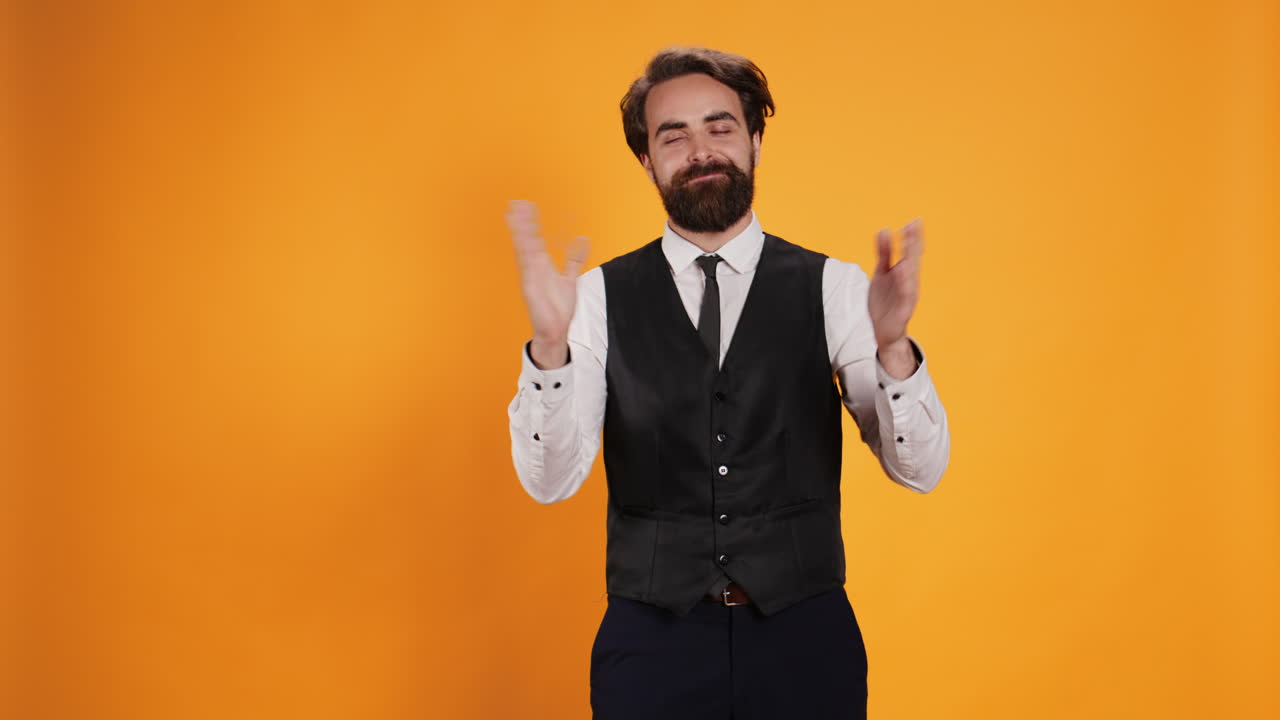 Un maggiordomo positivo che applaude alla telecamera.