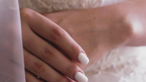 lady holds gentle hands with manicure and word bride on nail