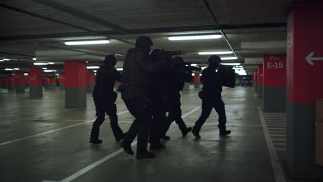 las fuerzas especiales exploran el estacionamiento. el equipo de operaciones especiales de la policía dispara con rifles.