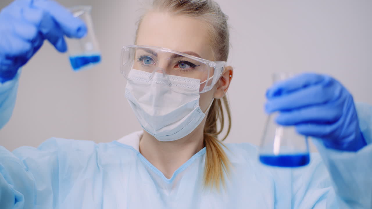 женщина-ученый держит в руках пробирки и колбу с жидкостью 9