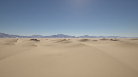 vast desert landscape with sand dunes and a mountain range in the distance