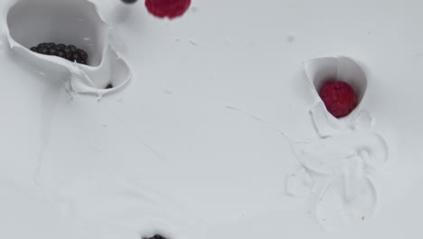 juicy berries falling yogurt in super slow motion closeup. vitamin dairy dessert