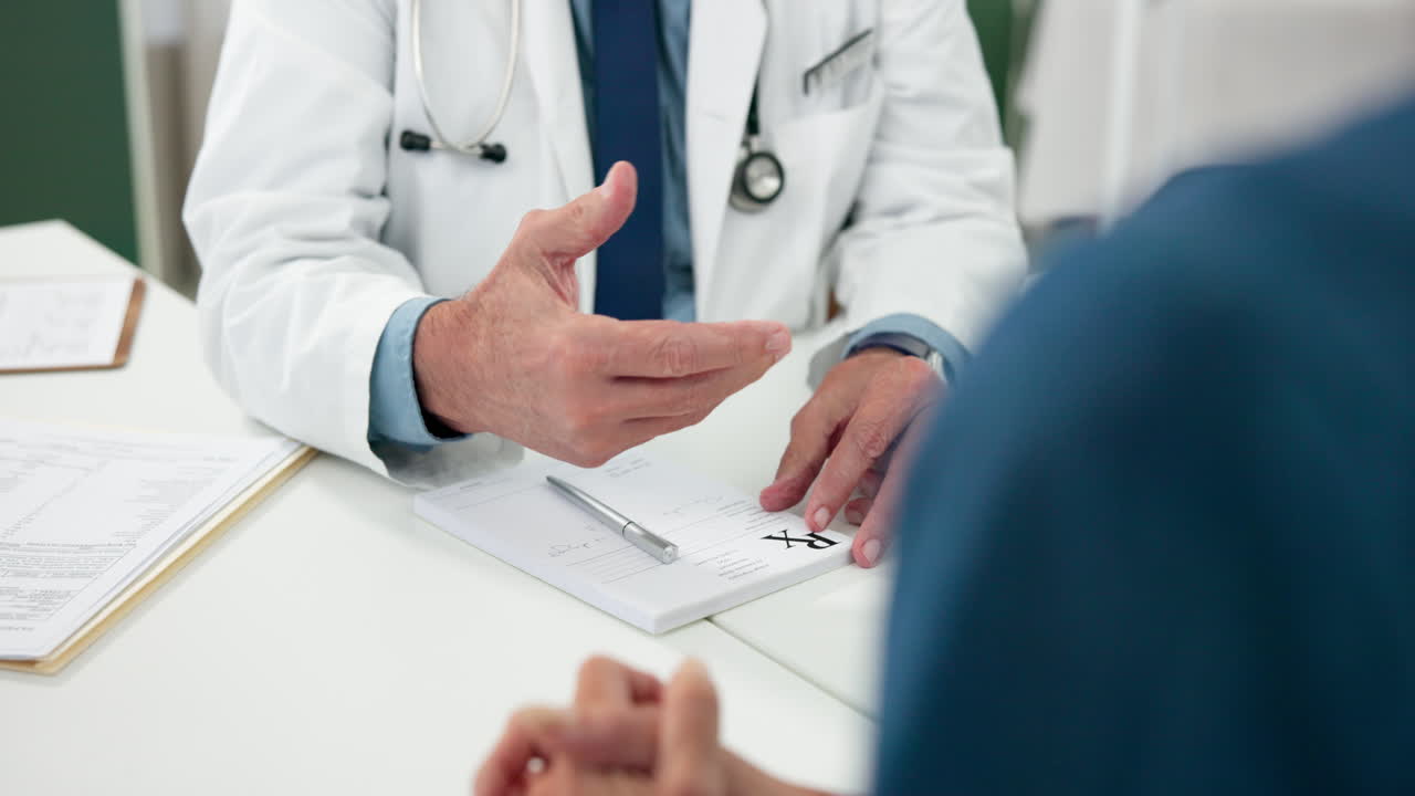 Médico escrevendo receita e explicando tratamento ao paciente