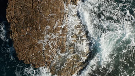 waves splashing on the sea rocks in pula, istria, croatia - aerial top down