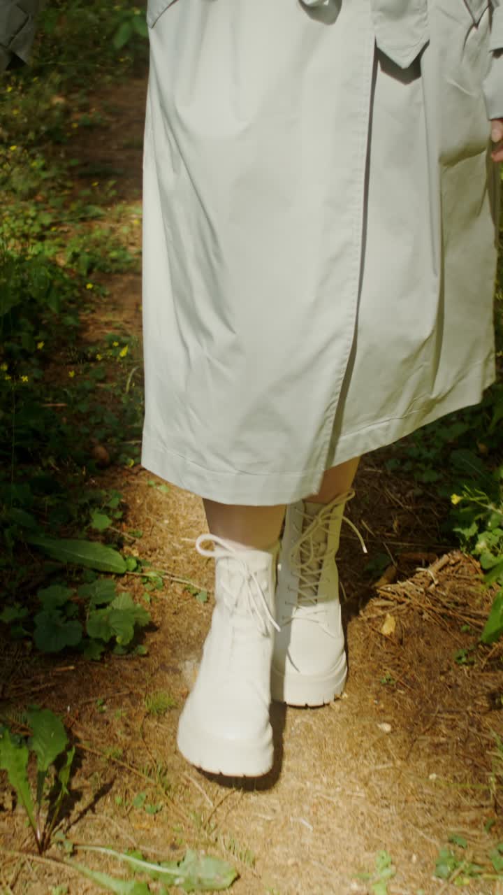 Woman in coat and boots walking on path