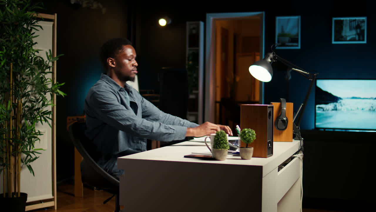 African American guy sitting at his home office and researching data