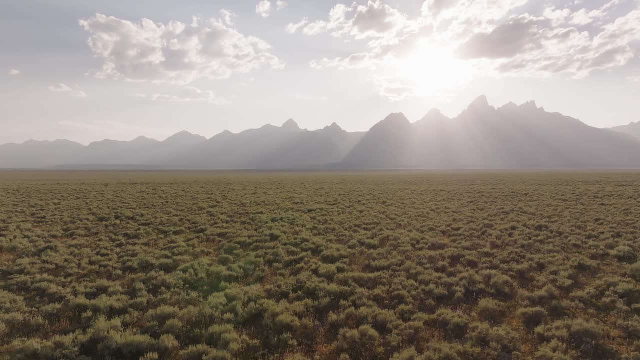 Drone shot revealing the Teton mountain range at sunset in Montana