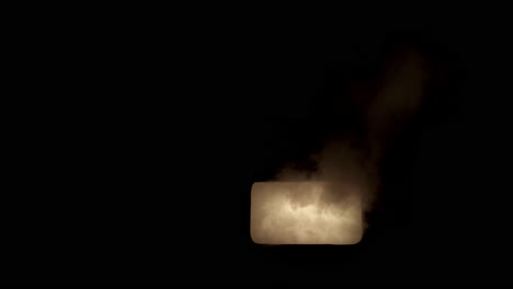 Slow motion smoke billowing out of window lit with a flickering, glowing light.