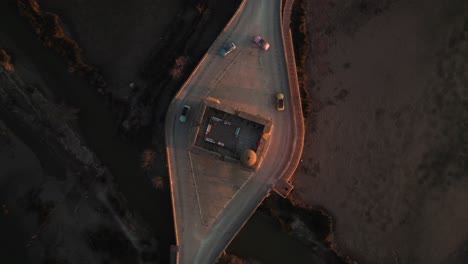 hay una estructura de piedra con una carretera donde los coches están pasando, y a cada lado, hay cuerpos de agua y tierra