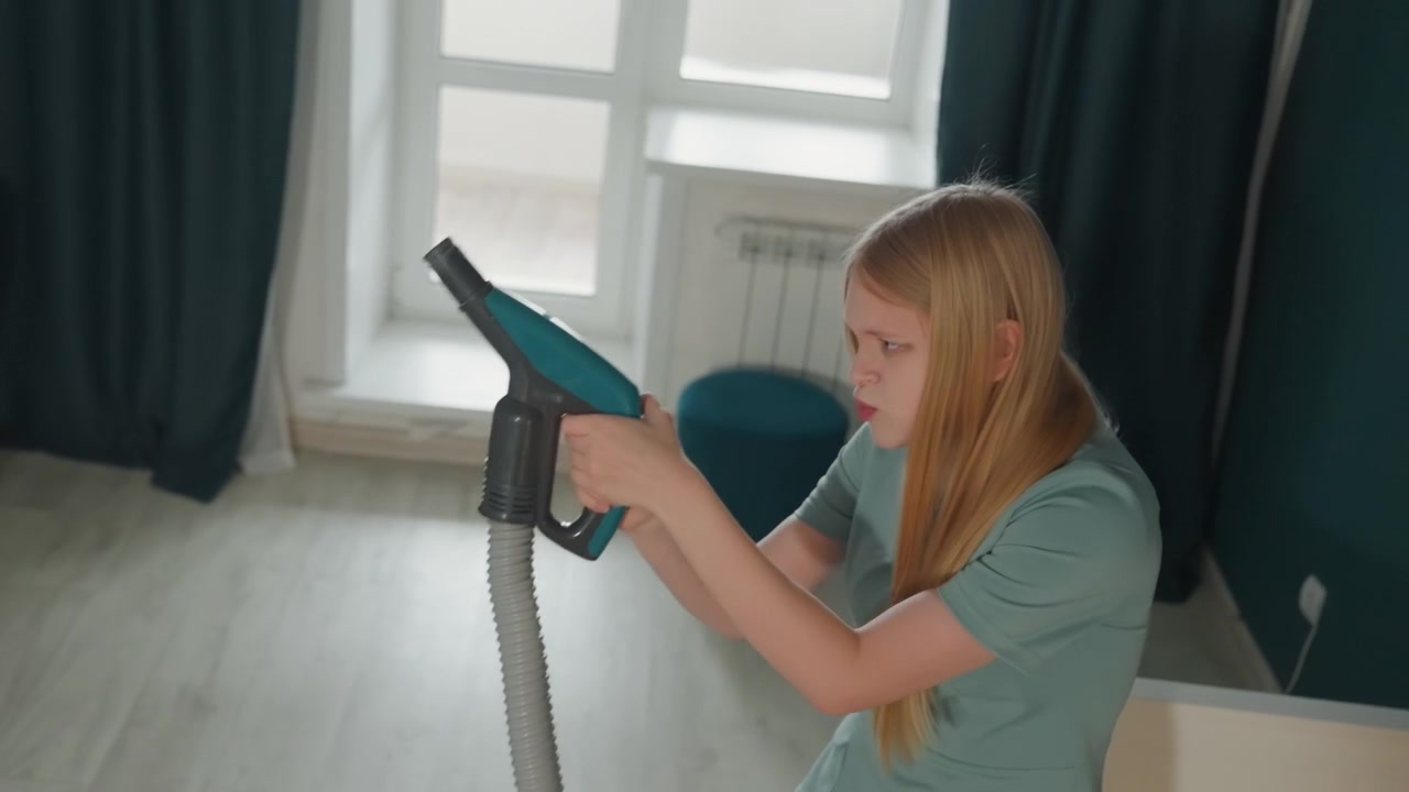 Femme blonde nettoyant la chambre à la vapeur, inspectant la buse du nettoyeur vapeur portatif et essuyant le cadre de la fenêtre, se concentrant sur l'élimination de la poussière. Lumière naturelle du jour, rideaux sarcelle, intérieur moderne et minimaliste, posture attentive.