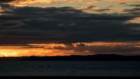 puesta de sol sobre un lago con nubes dramáticas