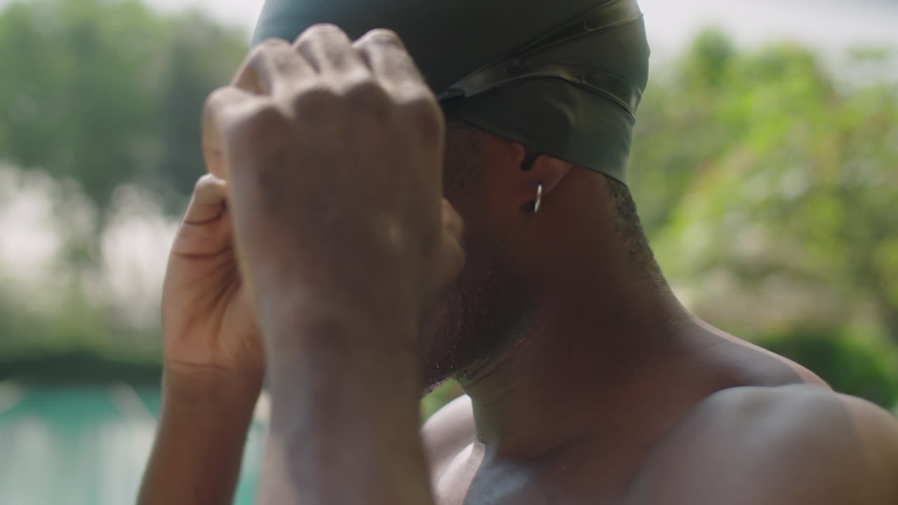 Black Swimmer Putting on Goggles before Outdoor Training