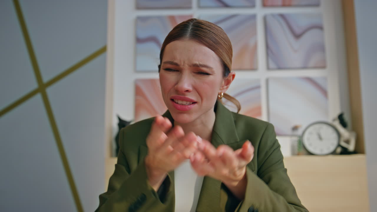 Displeased lady discussing work online sitting private cabinet alone closeup