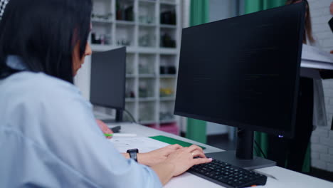 mujer codificando en su escritorio en una oficina