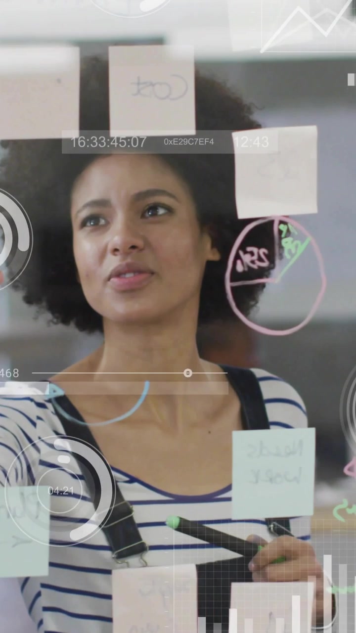 Vertical video: Woman placing notes after hand pointing at chart, HUD appearing over glass for biz