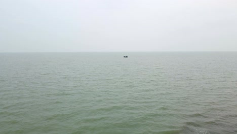 Aerial-shot-of-a-tiny-fishing-trawler-boat-at-Indian-ocean,-Bay-of-Bengal-during-monsoon