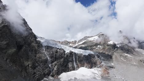 Fellaria-Glacier-and-lagoon-with-rocky-mountains-in-background,-Valmalenco-in-Italy