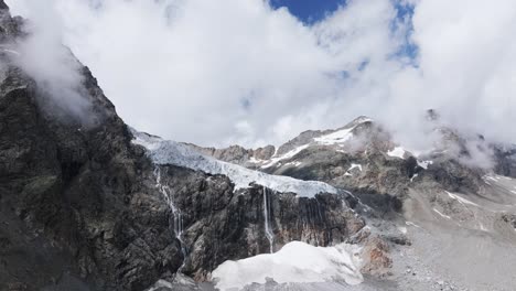 glaciar y laguna de fellaria con montañas rocosas en el fondo, valmalenco en italia