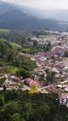 scenic aerial view of salento village's rustic charm, nestled among lush, green surroundings. vertical video, orbit motion