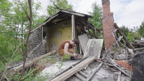 Video-journalist-working-on-location-at-a-storm-destroyed-house,-handheld