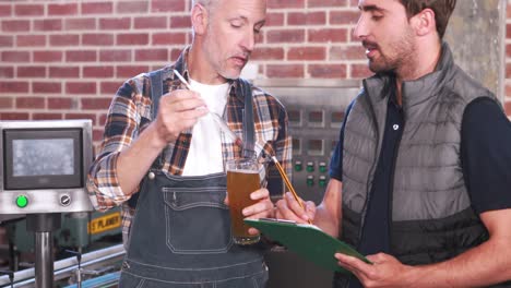 Dos-Hombres-Casuales-Probando-Cerveza-En-El-Vaso.