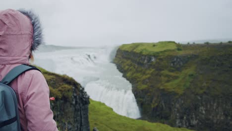 tourist woman looking at gullfoss waterfall the famous attraction and landmark destination on iceland on the golden circle