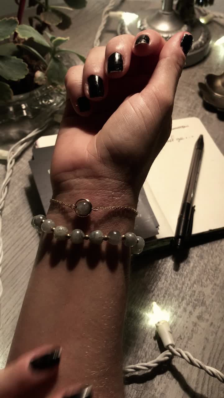 Woman's wrist with jewelry, in a cozy night setting