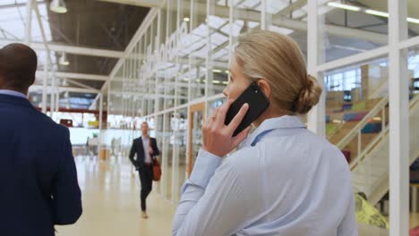 businesswoman using a smartphone walking in a conference foyer