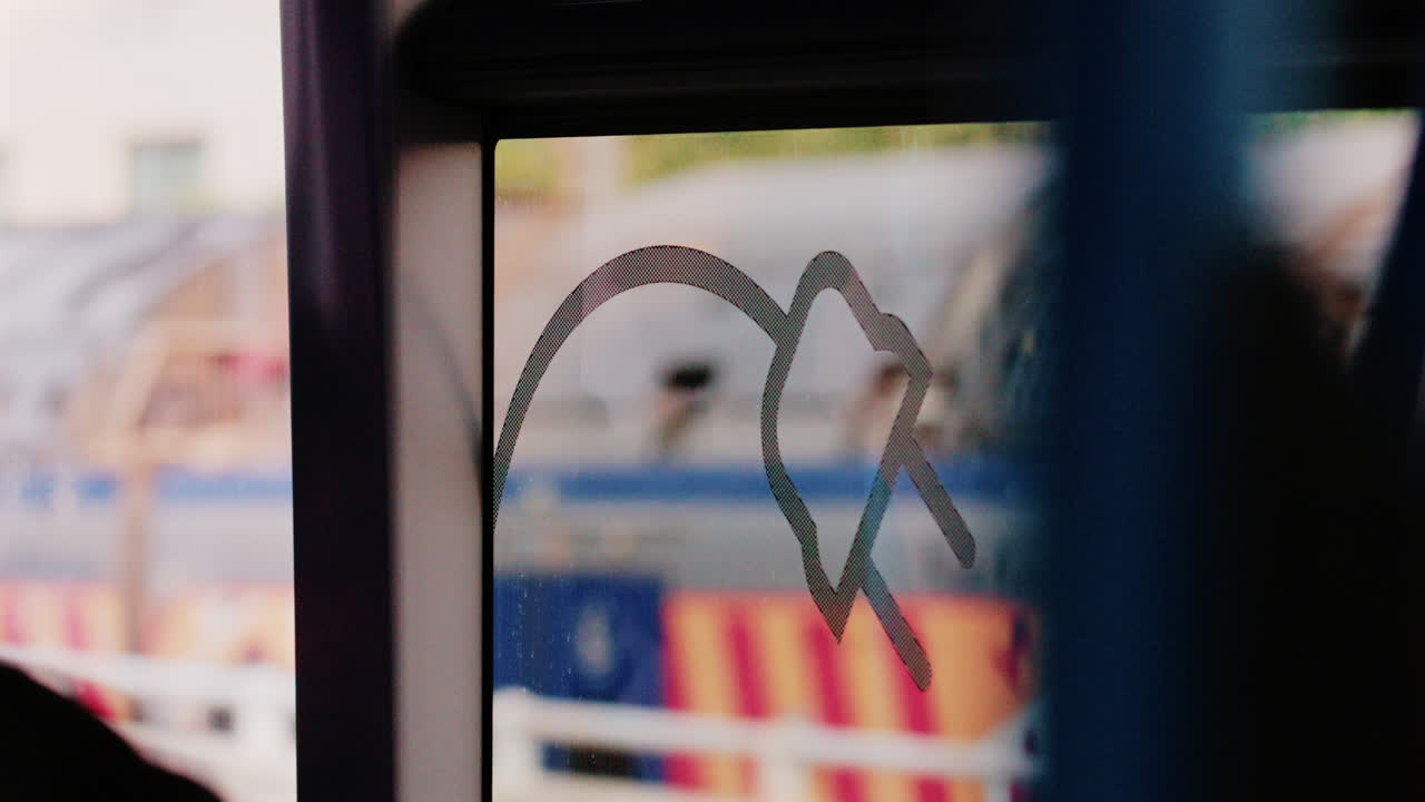 Blurred view through a train window with city reflections and graffiti