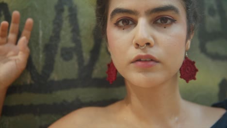 close up of a indian woman with red earrings looking at the camera