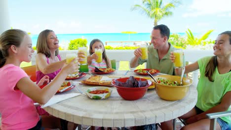 young caucasian family dining outdoors on beach decking