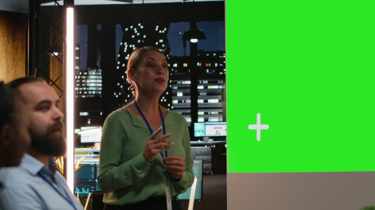 Multiethnic people collaborating for a meeting at night with a green screen