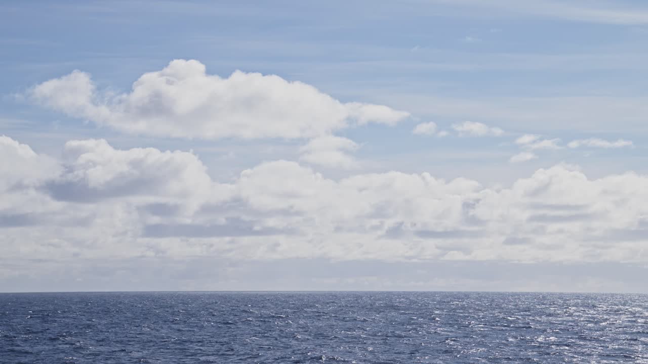 Open Ocean and Horizon View from Ship, Gentle Calm Sea Water and Waves Swell and Blue Sky with Clouds, Vast Endless Sea Background with Copy Space from Moving Boat Cruise Ship Trip