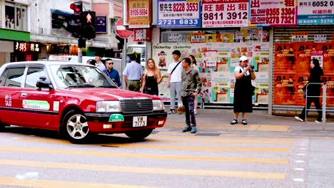 taxi moves through busy hong kong intersection