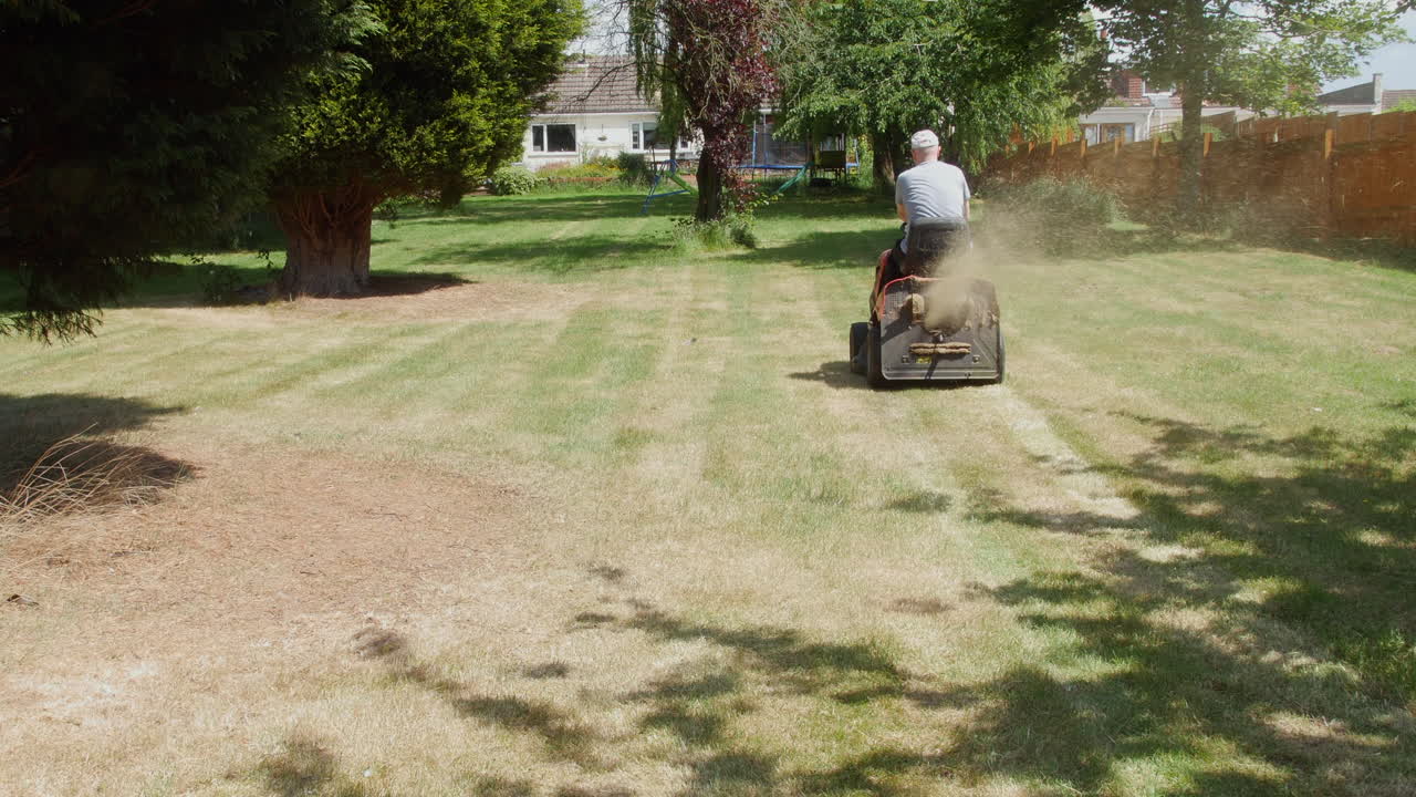 잔디밭을 타고 정원에서 잔디를 자르는 정원사