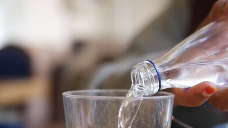 pouring water from a bottle into a glass