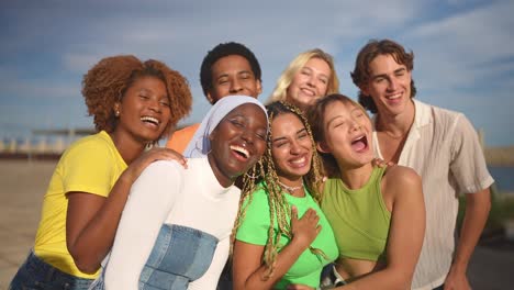 multiracial group of people smiling taking a selfie outdoors
