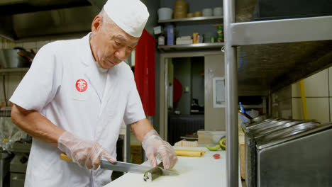 Male-chef-cutting-rice-rolls-in-kitchen-4k