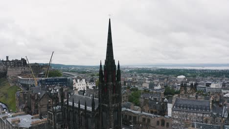 spectacular aerial of the hub tower, reveal of edinburgh castle and cityscape of the capital of scotland