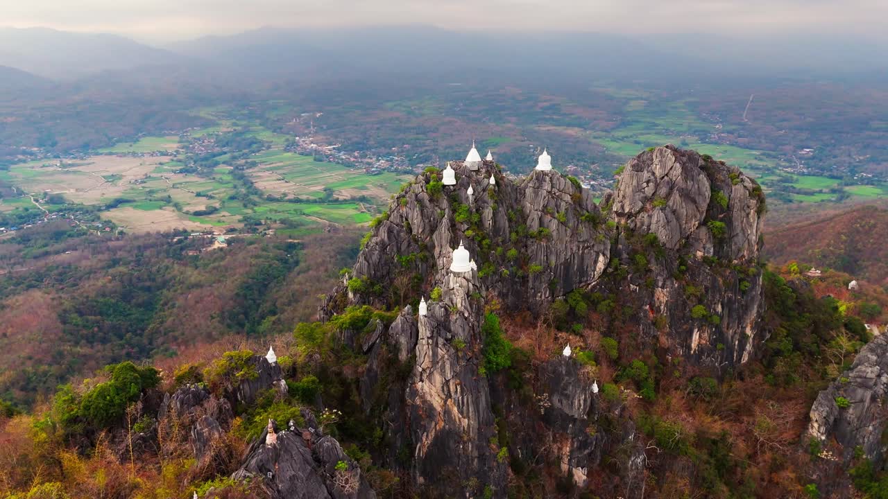aerial view of jaw dropping mountaintop pagodas of Wat Chaloem Phra Kiat near Lampang sky temple Thailand
