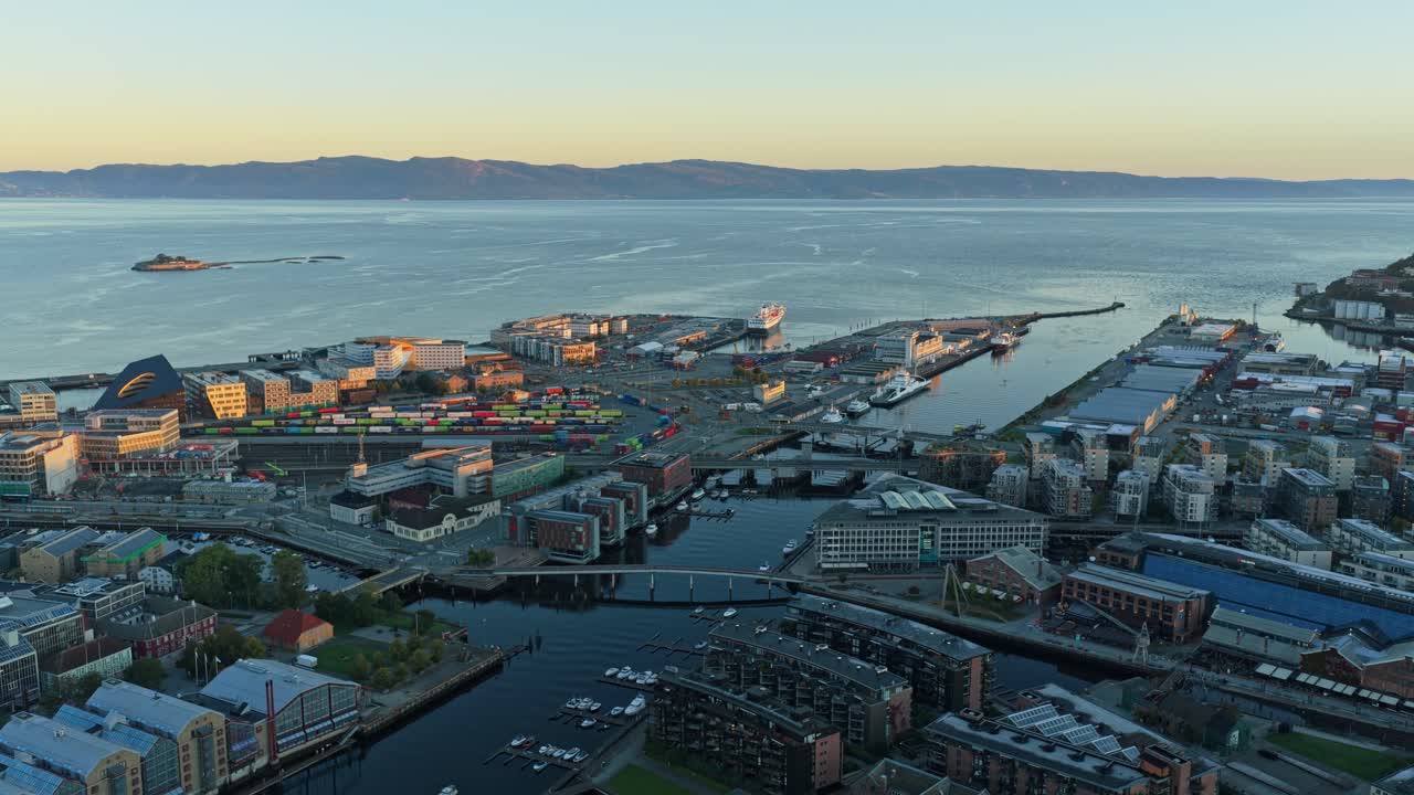Luftaufnahme des Hafenbereichs in Trondheim, getaucht in warmes goldenes Morgenlicht.