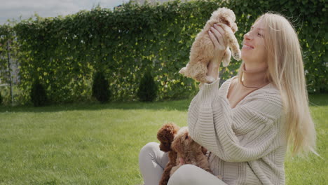 portrait of a happy pregnant woman. playing with puppies on a green lawn