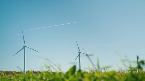 jet trail over two wind turbines