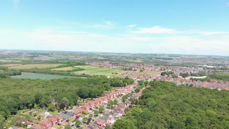 Wood-Walk,-Wombwell-woods---red-properties-on-sunny-day,-pedestal-aerial